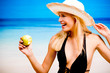 Young smiling woman with apple on the beach