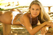 Foto: Blonde bikini swimsuit model laying on the beach Blonde bikini swimsuit model laying on the beach