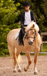 Ragazza bionda cavalca un pony