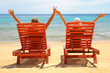 Foto: A couple resting by the beach on a red sun chair A couple resting by the beach on a red sun chair