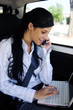 Photo: business travel: businesswoman with laptop in car business travel: businesswoman with laptop in car