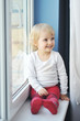 girl sits at  window