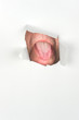 Man sticking out tongue through paper