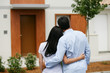 Couple debout de dos devant une maison Couple debout de dos devant une maison