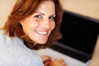Happy young woman with a laptop at home