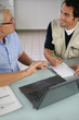 Hommes devant ordinateur portable dans un bureau