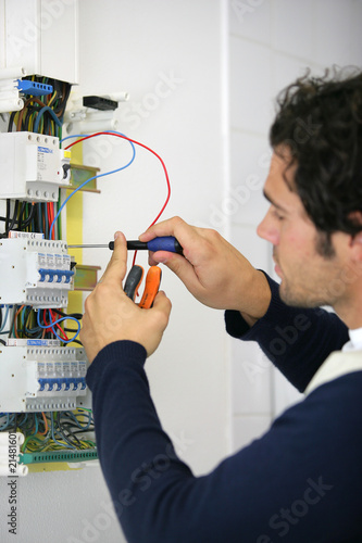 Foto: Portrait d'un électricien travaillant sur un compteur électrique Portrait d'un électricien travaillant sur un compteur électrique