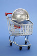 Metal puzzle globe with shopping cart on blue background