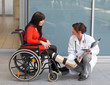 Woman with leg in plaster, a physician and chair