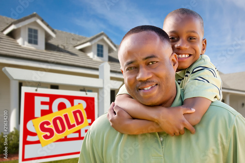 Photo: Father with Son In Front of Real Estate Sign and Home Father with Son In Front of Real Estate Sign and Home