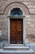 Old brown door of a Greek temple with arch