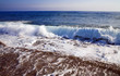 foamy shore blue waves in a clear summer day