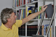 Mann nimmt ein Buch aus dem Regal Mann nimmt ein Buch aus dem Regal