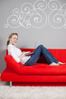 frau mit laptop auf rotem sofa