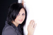 Dunkelhaarige Beauty lehnt an weiße Wand