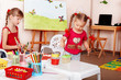 Group of children  with colour pencil in play room.