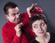 Man examining woman's hair with magnifying glass Man examining woman's hair with magnifying glass