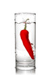 red pepper dropped into water glass with bubbles