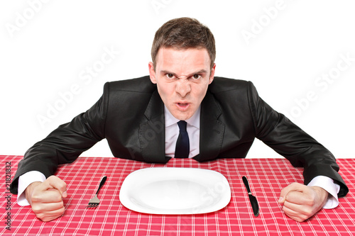 Photo: An angry man waiting his food in a restaurant An angry man waiting his food in a restaurant