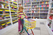 girl in bookshop, with cart for purchases