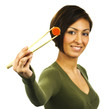 Young happy woman holds a carrot slice with chopsticks Young happy woman holds a carrot slice with chopsticks