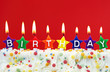 Colorful birthday candles on red background
