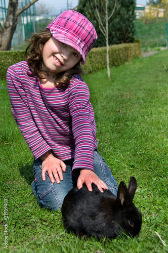 Foto: Mädchen mit Kaninchen im Garten Mädchen mit Kaninchen im Garten
