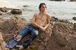 Muscular man laying on the rocks on the beach.
