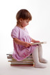Little girl reading a book on white
