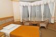 Single bed in modern hotel room with table and chairs