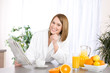 Breakfast - Smiling woman reading newspaper in kitchen Breakfast - Smiling woman reading newspaper in kitchen