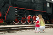 Woman with child beside locomotive Woman with child beside locomotive