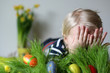 Photo: Cute boy hiding in studio behind grass with easter eggs Cute boy hiding in studio behind grass with easter eggs
