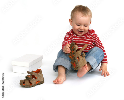 Foto: Baby and shoes - child tries to put on shoes Baby and shoes - child tries to put on shoes