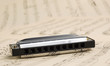Harmonica laying on old grunge notes background