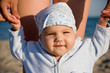 Mother keeps her child's hands on the beach