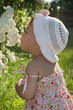 Little child enjoys the scent of flowers