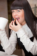 Foto: Young girl in cafe is drinking coffee Young girl in cafe is drinking coffee