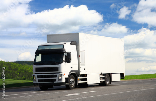 Photo: White truck driving on a road White truck driving on a road