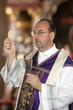 Katholischer Priester bei der Kommunion im Gottesdienst