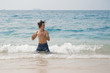 Athletic man in the Pacific ocean shaking his wet hair.