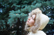 The girl looks at the green spruce