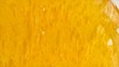 Clear bubbles floating in a vibrant yellow gel