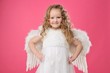 Beautiful little angel girl isolated on pink background