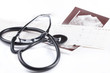 A stethoscope on the top of the EKG chart and USG picture