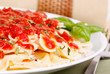 Bowtie pasta with marinara sauce and basil garnish Bowtie pasta with marinara sauce and basil garnish