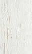 Peeling paint on a white wooden wall background closeup.