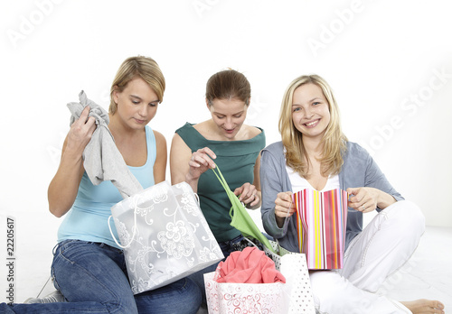 Photo: drei freundinnen beim auspacken der einkäufe drei freundinnen beim auspacken der einkäufe