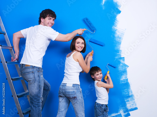 Photo: Young family painting the wall Young family painting the wall