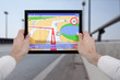 hands holding a touchpad pc, using the navigation programme
